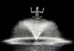 girl sitting on top of a water fountain