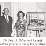 Man and woman standing next to a framed painting of a sailboat displayed on an easel.
