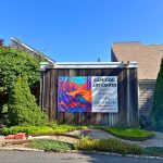 Cape Cod Art Center exterior with large colorful promotional banner.